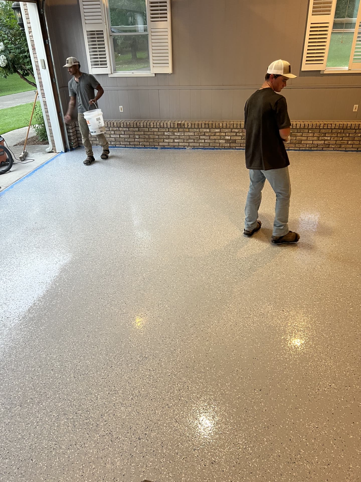 Summit Surface installers finishing a coated garage floor